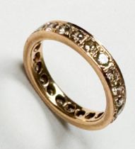 A yellow metal (probably 18ct) full eternity ring, claw-set with round brilliant cognac coloured