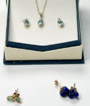 A 9ct yellow gold pendant and chain, bezel-set with an oval-shaped blue topaz, and a small diamond