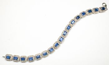 A silver bracelet, set with 17 x rectangular shaped sapphires, each sapphire claw-set with small