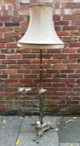 A brass standard lamp of neo-classical form with tripartite base and draped swags