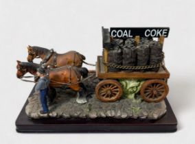 A composition-moulded and hand-painted model of a coalman with dray and two shire horses, on moulded