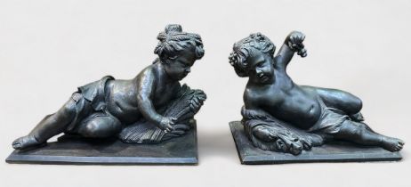 A pair of 20th century large 'bronzed' moulded composition figures of recumbent putto, the girl