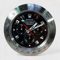 A Rolex authorised dealer display wall clock, modelled as a Rolex Daytona, the black dial with