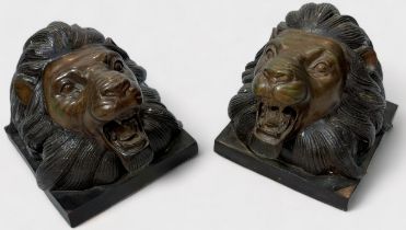 A pair of cast and patinated bronze lion's head bookends, 17cm high