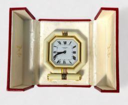 A Cartier travel alarm clock, with Swiss Quartz movement, Octagonal case with white bezel and tri-
