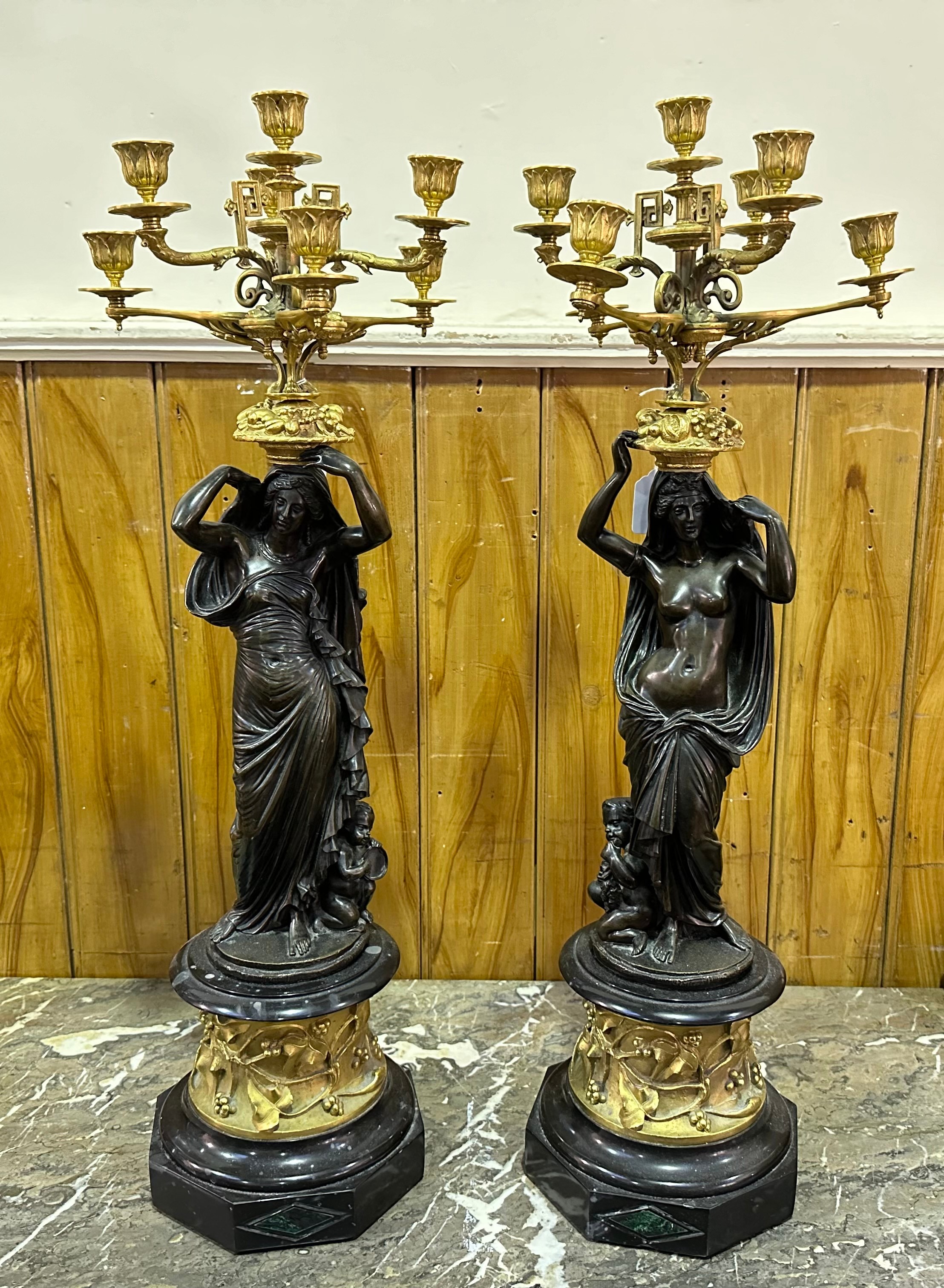 A pair of bronze and ormolu figural seven-light candelabra, each cast with a classical maiden