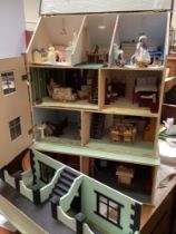 A hand made green painted dolls house arranged over four floors, with additional front section,