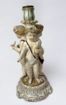 A 19th century continental porcelain figural candlestick, modelled with three Putti emblematic of