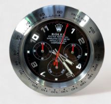 A Rolex authorised dealer display wall clock, modelled as a Rolex Daytona, the black dial with