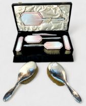 A six-piece silver and pink guilloche enamel dressing table set by Albert Carter, comprising four