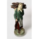 A Royal Dux pottery figure of a female 'faggot gatherer,' modelled with head-scarf and a loaded