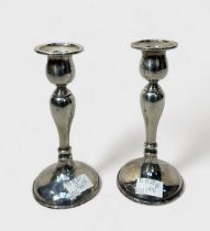 A pair of silver candlesticks of inverted baluster form, with loaded bases, 18cm high, British