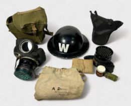 A WW2 Air Raid Warden's helmet and three gas masks, together with two large brass artillery shells