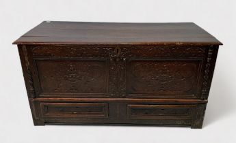An early 18th century stained oak mule chest, with later carved front and applied split-bobbin