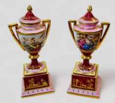A pair of 19th century Viennna Porcelain pedstal vases and covers, with rouge grounds and pink