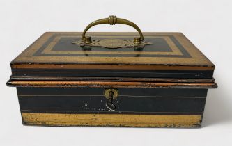 An early 20th century lockable black and gilded cash tin, with brass handle and hinged lid enclosing