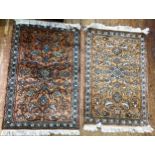 Two small machine made rugs, each with coloured geometric decoration to an orange ground, with