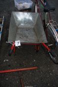 A galvanised wheelbarrow with solid tyre.