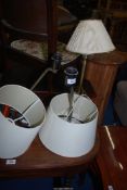 Three table lamps, one brass and two chrome, with shades.