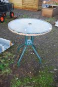 A garden table with glass top, 25" wide x 27 1/2" high.