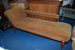A chaise longue with ceramic castors, upholstered in chestnut velour.