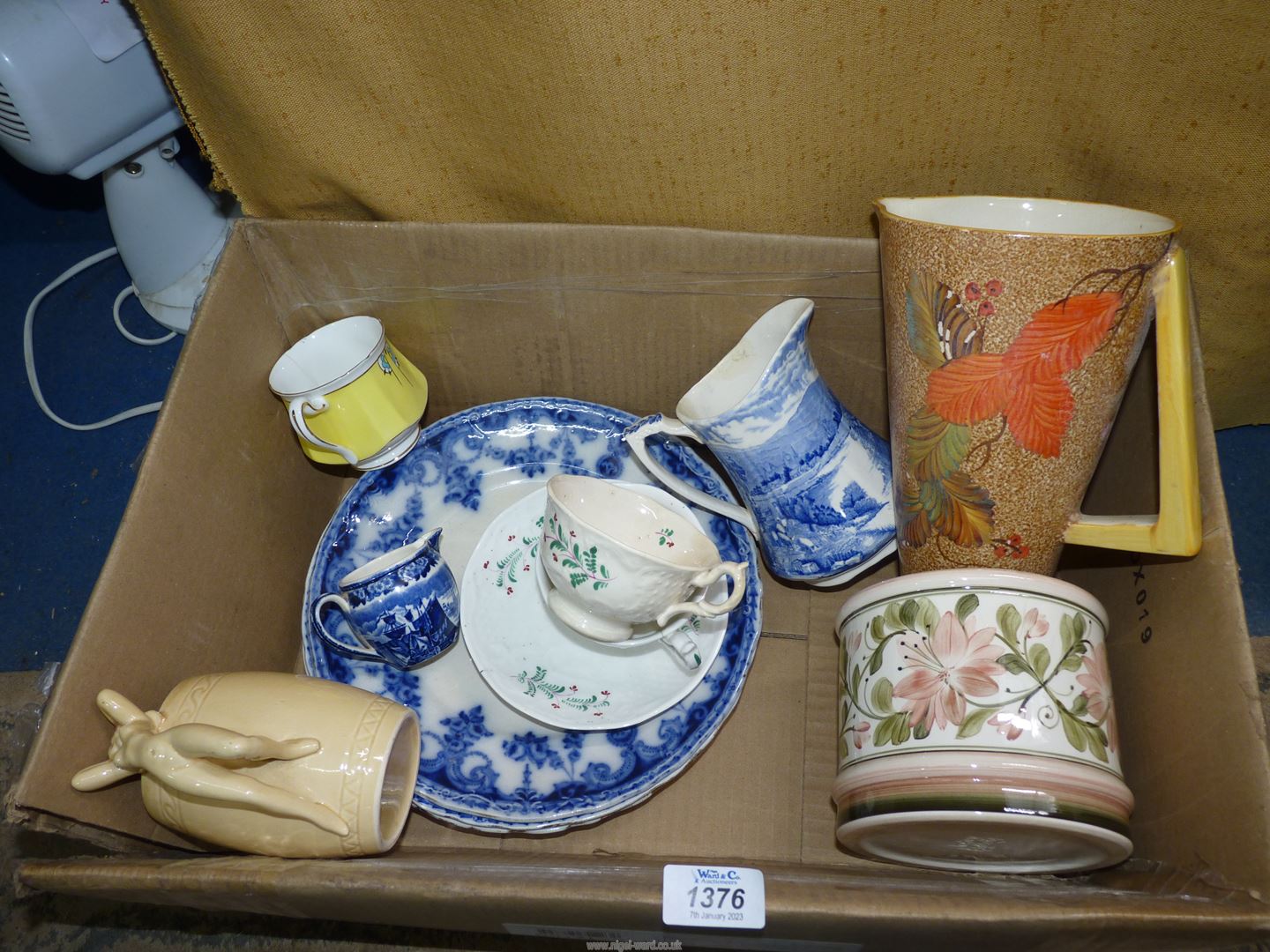 A box of china including blue and white plates, Jersey mug with nude lady, Art Deco jug,