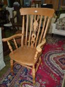 A contemporary lightwood Elbow/ Grandfather Chair having a solid seat, turned legs and arm supports,