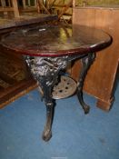 A circular dark stained wood topped Pub/Tavern Table standing on heavy black painted cast iron base
