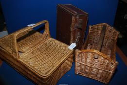 A wicker picnic basket, wine carrier and small suitcase.