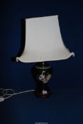 A twin black cloisonne table lamp with cream shade,