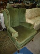 An elegant wing Fireside Chair standing on brief ball and claw front feet and upholstered in dark