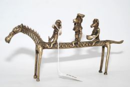 A cast metal African tribal sculpture of three comical animal figures on horseback,