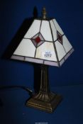 A small Tiffany style table lamp with white ground and purple diamond pattern (one panel cracked),