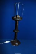 A tall bronze effect Arts and Craft Candle Holder converted to a table lamp with floriate shaped