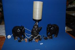 A quantity of Ebony and treen Elephants including large table lamp,