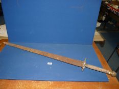 A heavy, steel, theatrical copy of a medieval broadsword with wooden rolled handle,