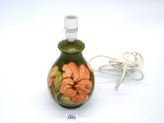 A pretty Moorcroft lamp base with a coral Hibiscus pattern.