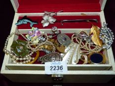 A cream jewellery box containing costume jewellery, faux pearl necklaces,