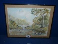 A framed Watercolour depicting a river landscape with trees and a bridge, signed lower right R.N.