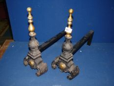 A pair of cast iron and brass fire dogs.