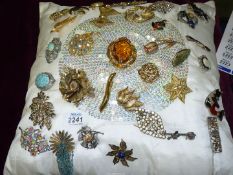 A cushion full of brooches in various styles to include; turquoise, glass, Celtic, bar brooches,
