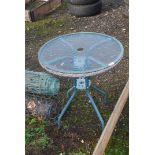 A circular glass top table, 25" wide x 27" high.