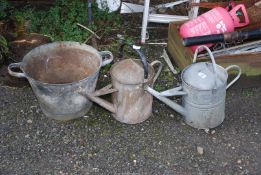 Two galvanised watering cans and a galvanised planter.