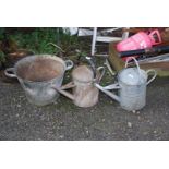 Two galvanised watering cans and a galvanised planter.