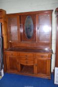 An Oak dresser with glazed cabinets either side of central mirror to top,