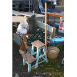 A wooden step stool with pole handle.