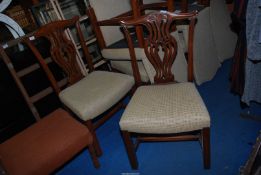 A pair of upholstered seated dining chairs with fretwork splats.