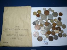 A cloth bag marked 'Standard Bank of South Africa 1944' and contents of coins including Portuguese,