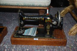 A cased Singer hand sewing machine with attachments, serial no F9865597, in bentwood case.