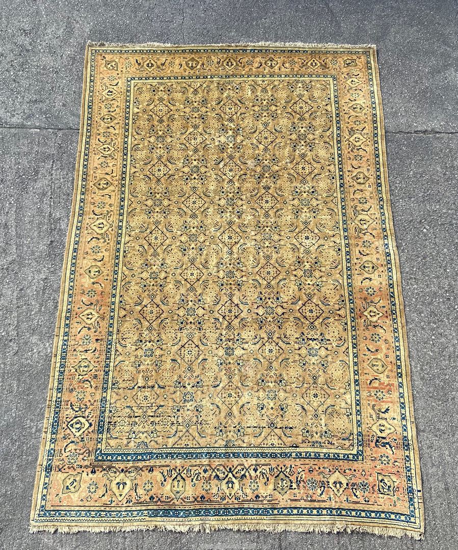 An antique Mahal Wool carpet - West Persia with overall Herati style floral design on camel field.